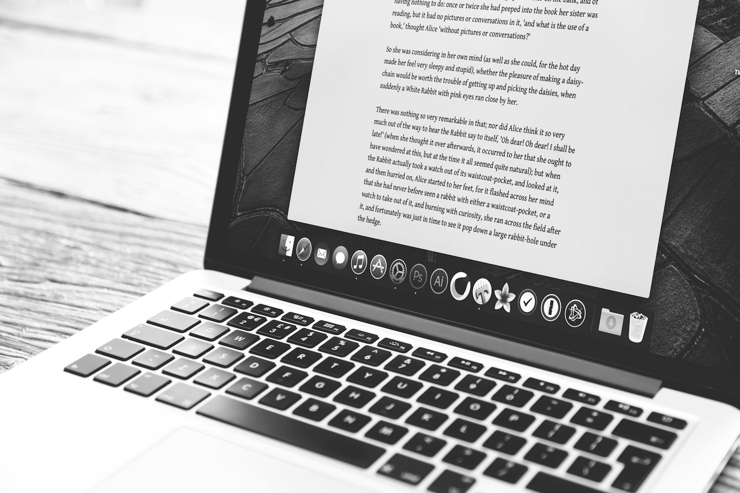 Computer portatile aperto su una scrivania di legno chiaro con testo sullo schermo.