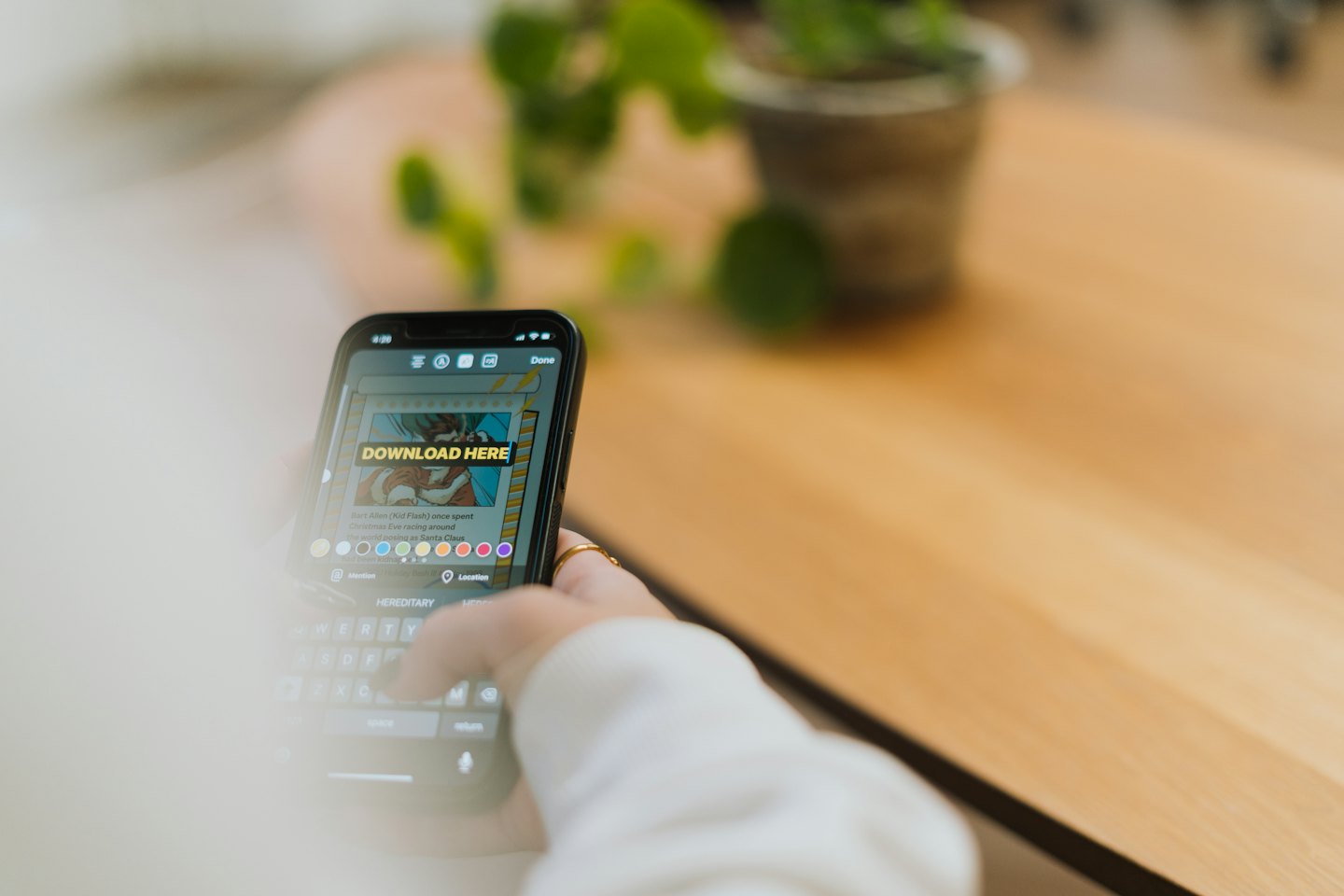 Mani che tengono uno smartphone con un prompt di download dei social media.